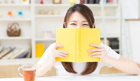 Woman reading book and smiling